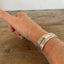BADASS hand-stamped spoon cuff bracelet shown on model wrist - vintage 1932 Tudor Plate silverplate with empowering message