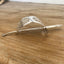 Side view of vintage cake server hair barrette showing curved silverplate shape