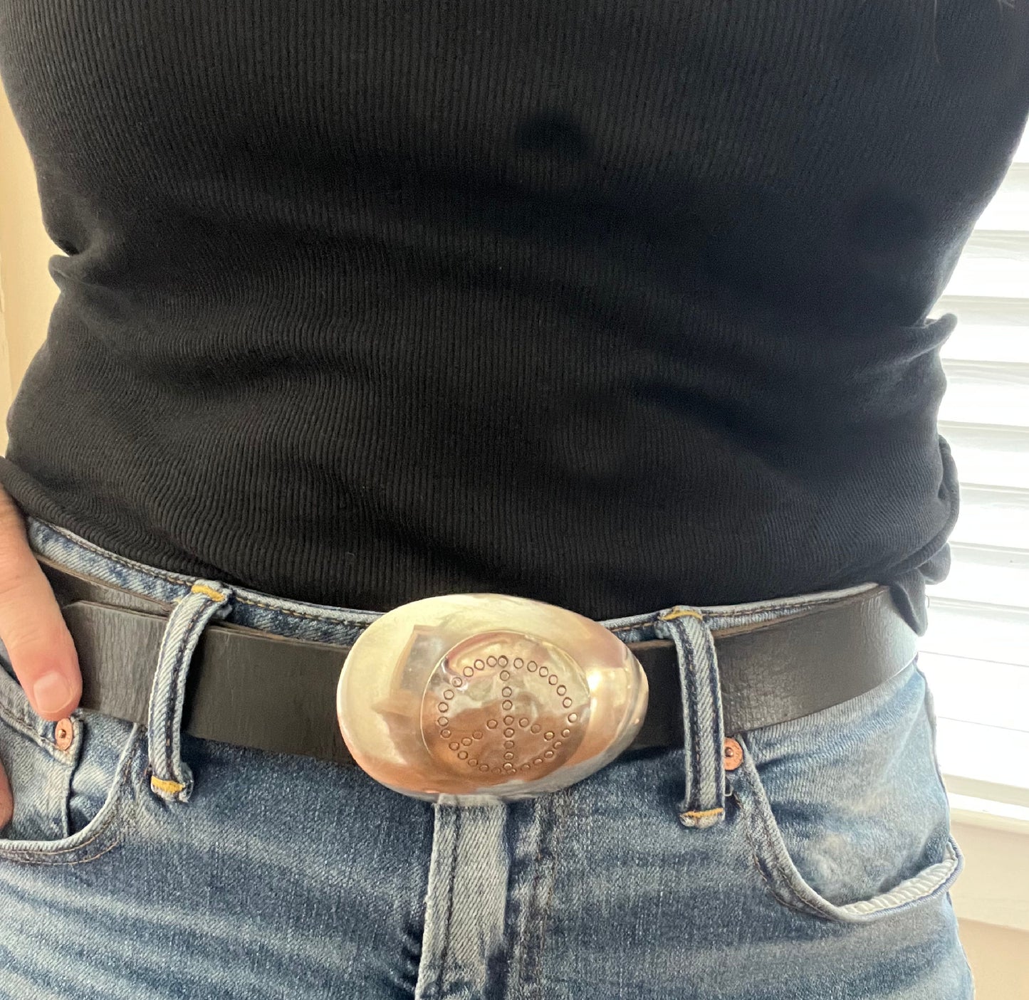 PEACE spoon belt buckle modeled on leather belt showing hand-stamped peace symbol and upcycled silverware craftsmanship, lefty design