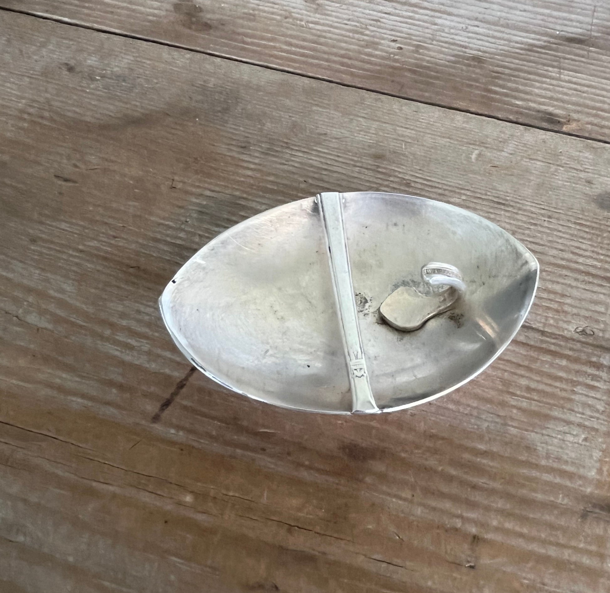 Back view of stylized star spoon belt buckle showing buckle mechanism for 2-inch leather belt, handcrafted from vintage silverware