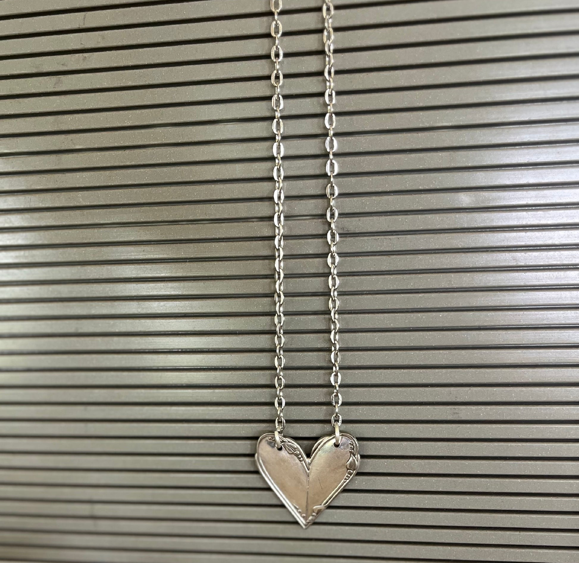 Shot of a hanging MEADOWBROOK pattern fork handle heart necklace - Fork Handle Heart Necklace - handcrafted from upcycled vintage silverware - Laughing Frog Studio