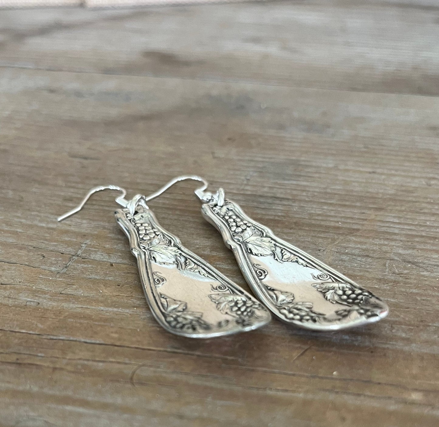 Close-up detail of grape cluster design on La Concorde spoon handle earrings, one-of-a-kind silverware jewelry