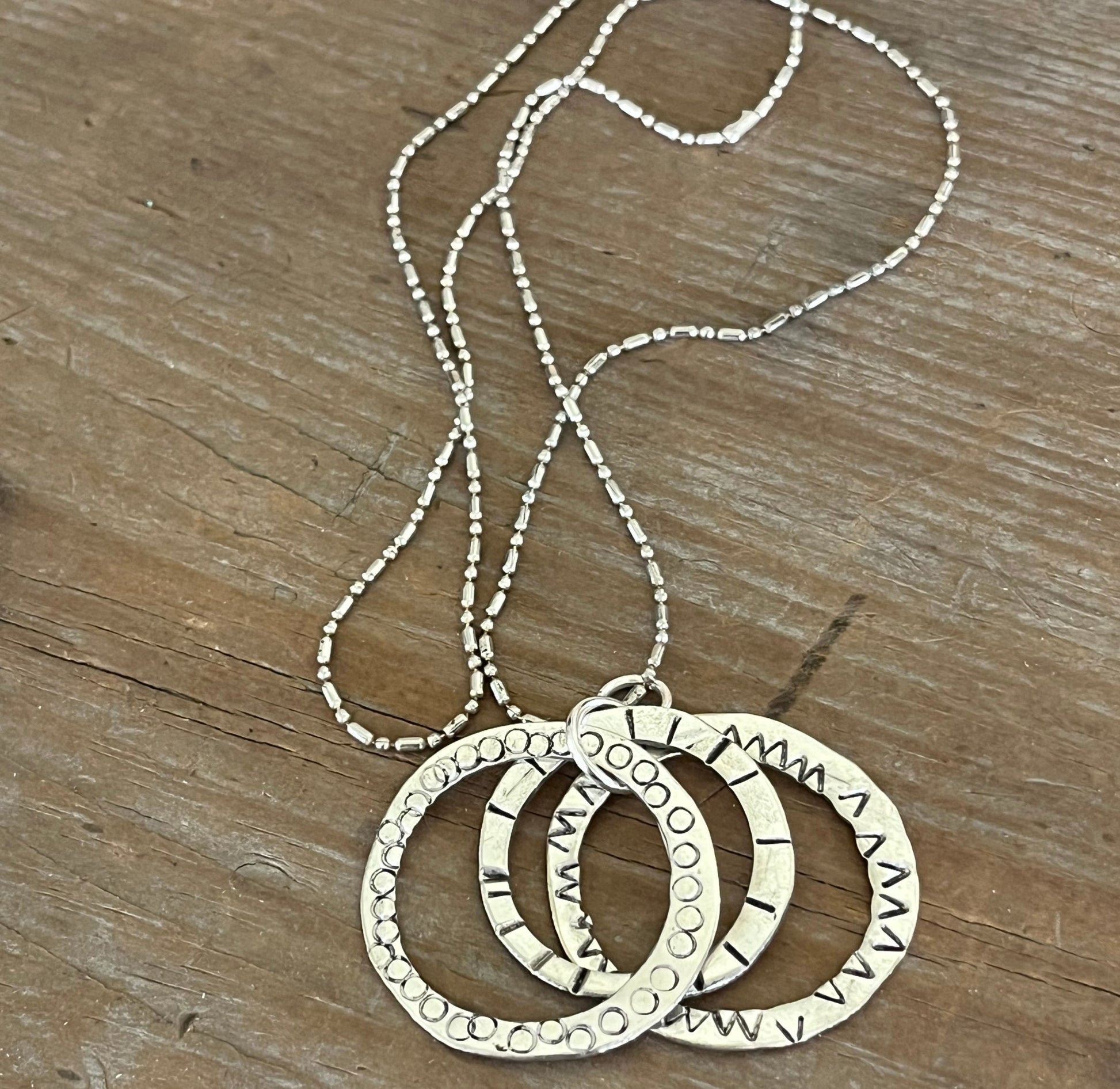 Close-up of hand-stamping on kinetic movement rings artisan spoon necklace - artisan silverware statement necklace - handcrafted from upcycled vintage silverware - Laughing Frog Studio