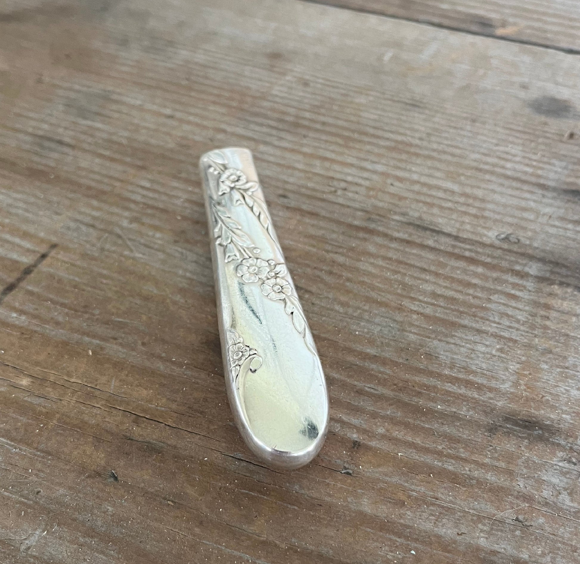 Close-up of handcrafted Bridal Wreath pattern knife vase showing romantic floral swirl detail and polished hollow handle
