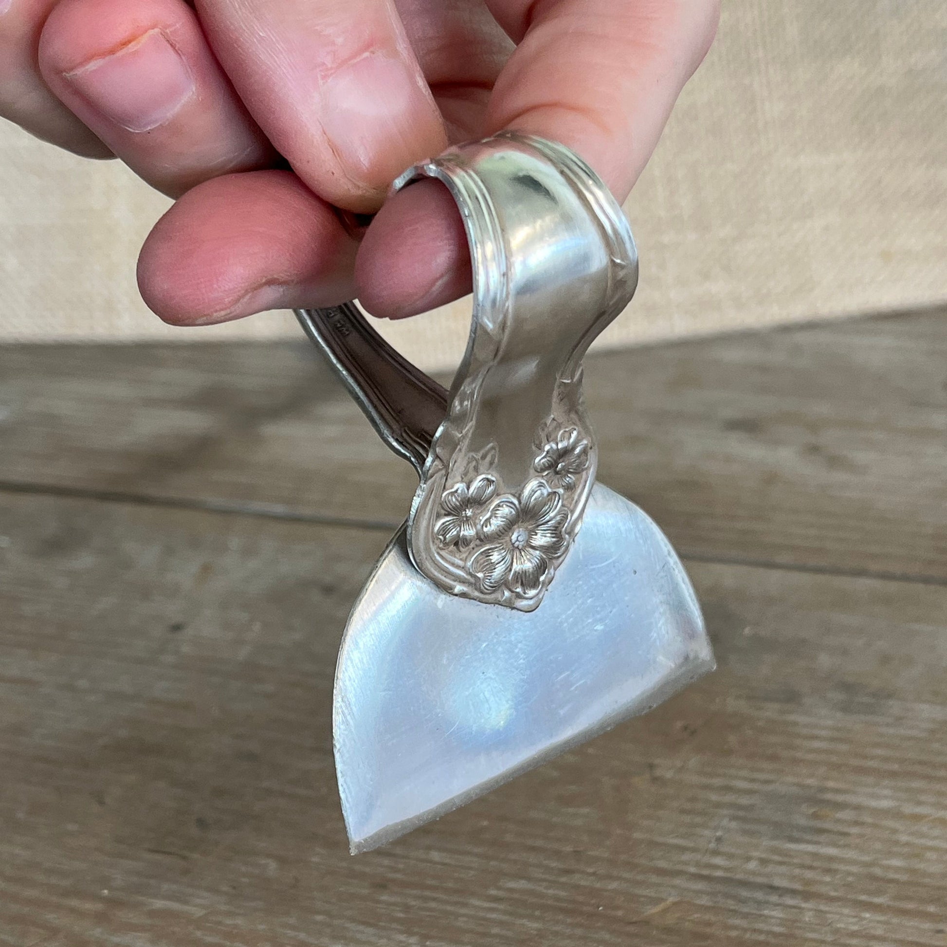 Arbutus pattern ergonomic heart handle cheese knife shown in hand- Ergonomic Heart Handle Cheese Knife - handcrafted from upcycled vintage silverware - Laughing Frog Studio