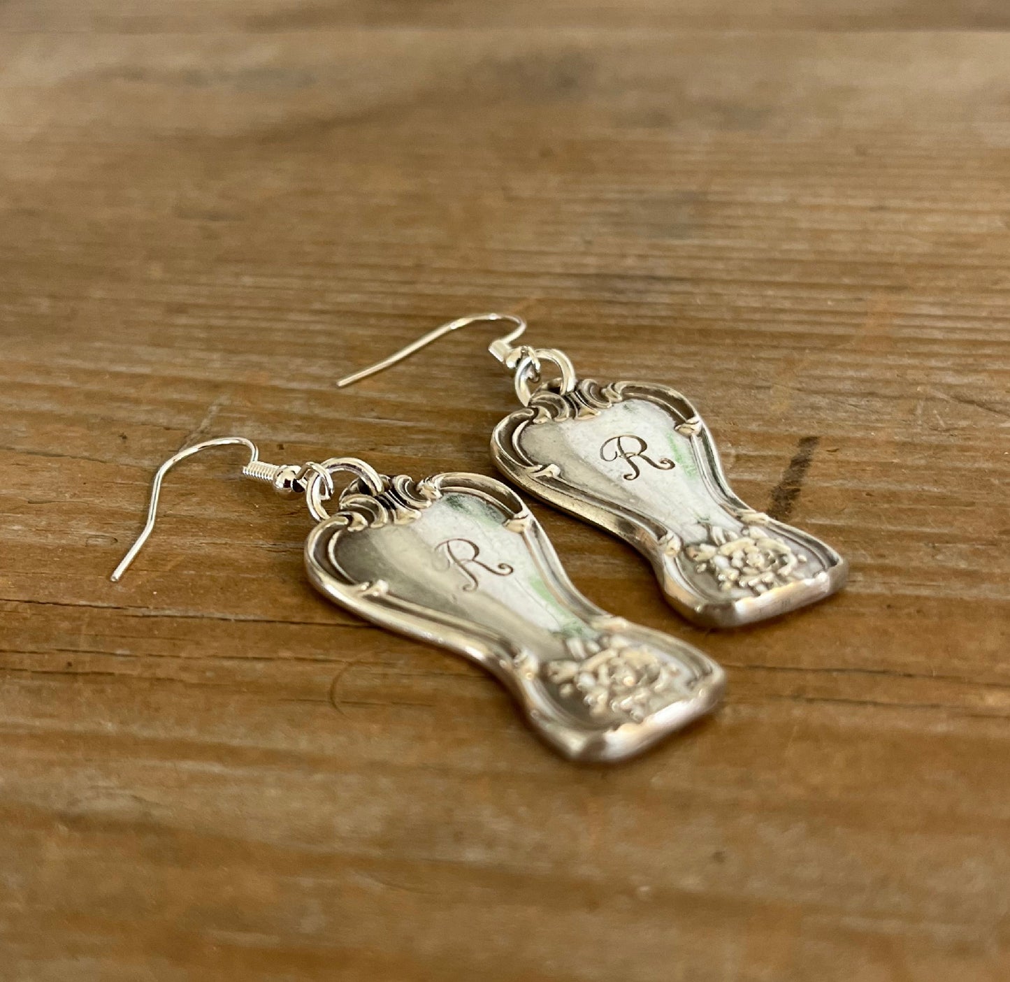 Close-up detail of 1950 Old Company Plate Signature pattern spoon handle drop earrings with monogram R - spoon earrings - handcrafted from upcycled vintage silverware - Laughing Frog Studio
