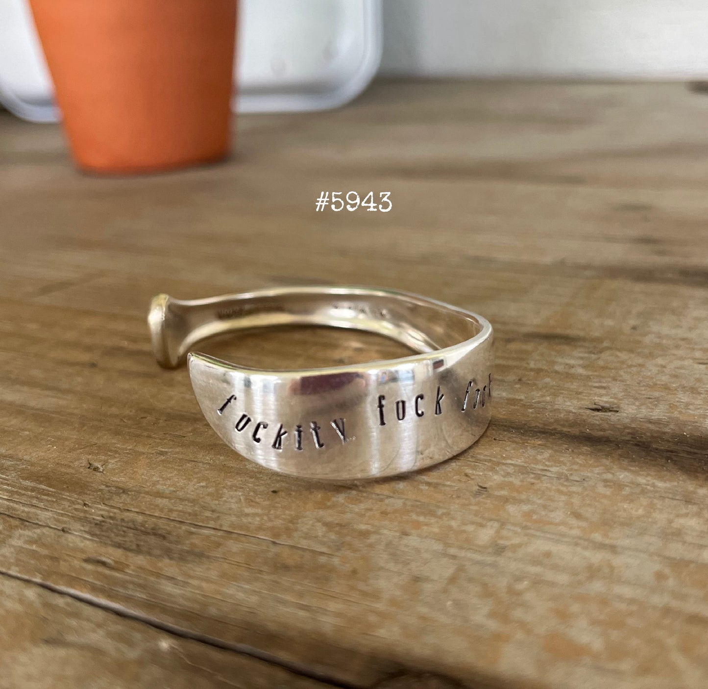 FUCKITY FUCK FUCK hand-stamped message on vintage silverplate Always/Wildwood pattern spoon cuff bracelet worn on model wrist - handcrafted from upcycled vintage silverware - Laughing Frog Studio