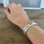 Silver spoon cuff bracelet from Prestige Silverplate Bordeaud pattern stamped fuckity fuck fuck on model's wrist - handcrafted from upcycled vintage silverware - Laughing Frog Studio