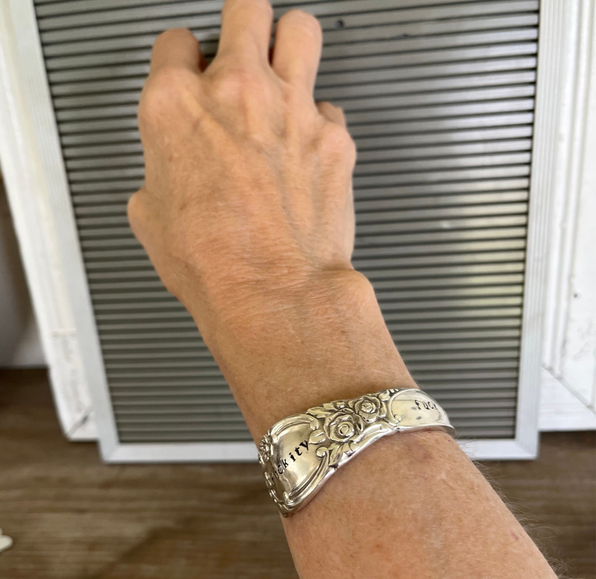Silver spoon cuff bracelet with floral rose pattern stamped fuckity on model's wrist - Oneida Ballad cuff bracelet - handcrafted from upcycled vintage silverware - Laughing Frog Studio