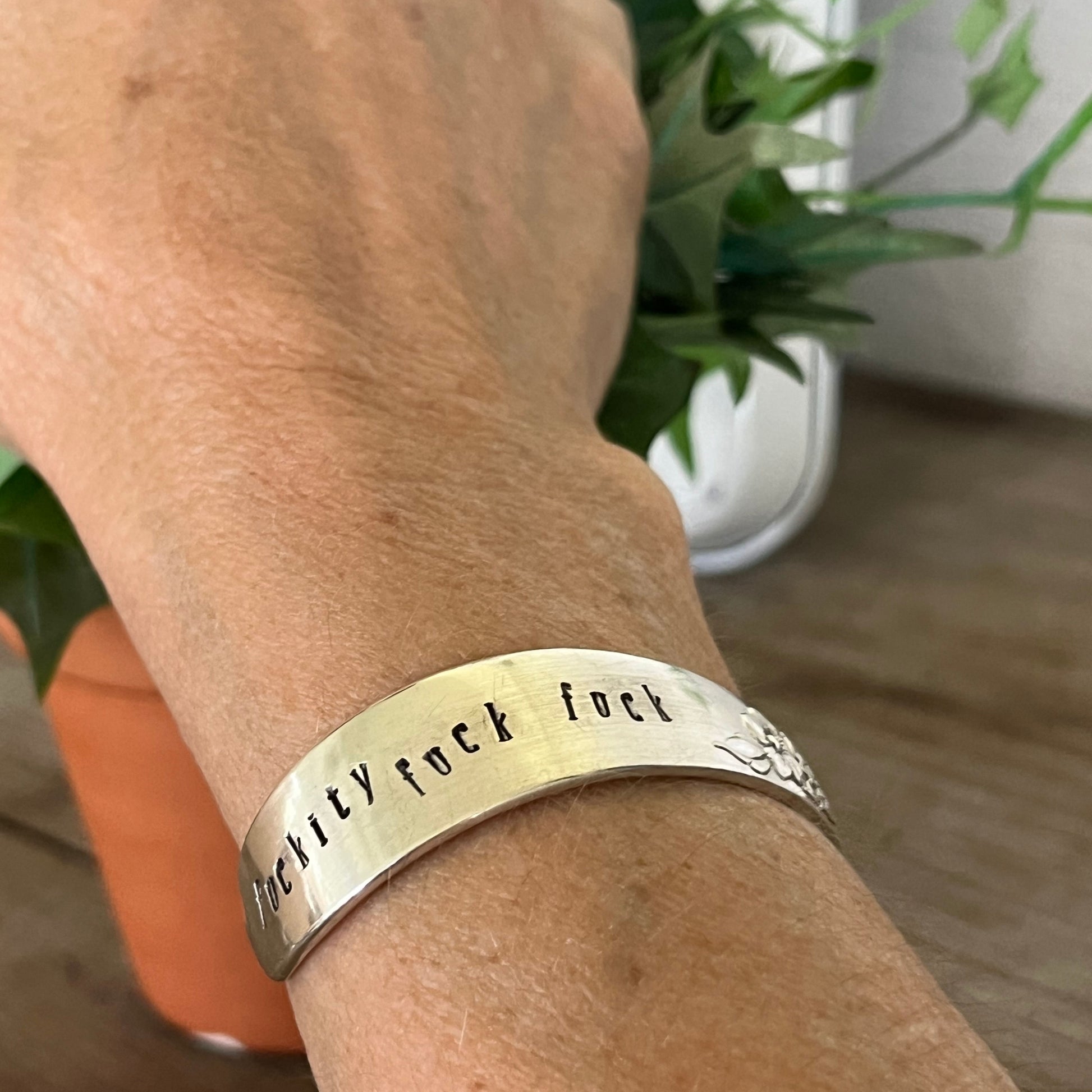 FUCKITY FUCK FUCK hand-stamped spoon cuff bracelet shown on model wrist - vintage 1958 Wm. A. Rogers silverplate with bold message 