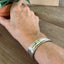 BADASS hand-stamped spoon cuff bracelet shown on model wrist - Stamped Spoon Bracelet - handcrafted from upcycled vintage silverware - Laughing Frog Studio
