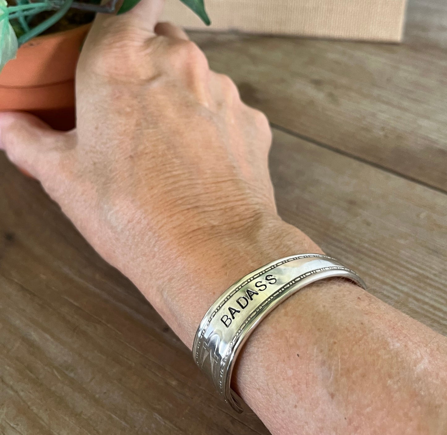 BADASS hand-stamped spoon cuff bracelet shown on model wrist - Stamped Spoon Bracelet - handcrafted from upcycled vintage silverware - Laughing Frog Studio