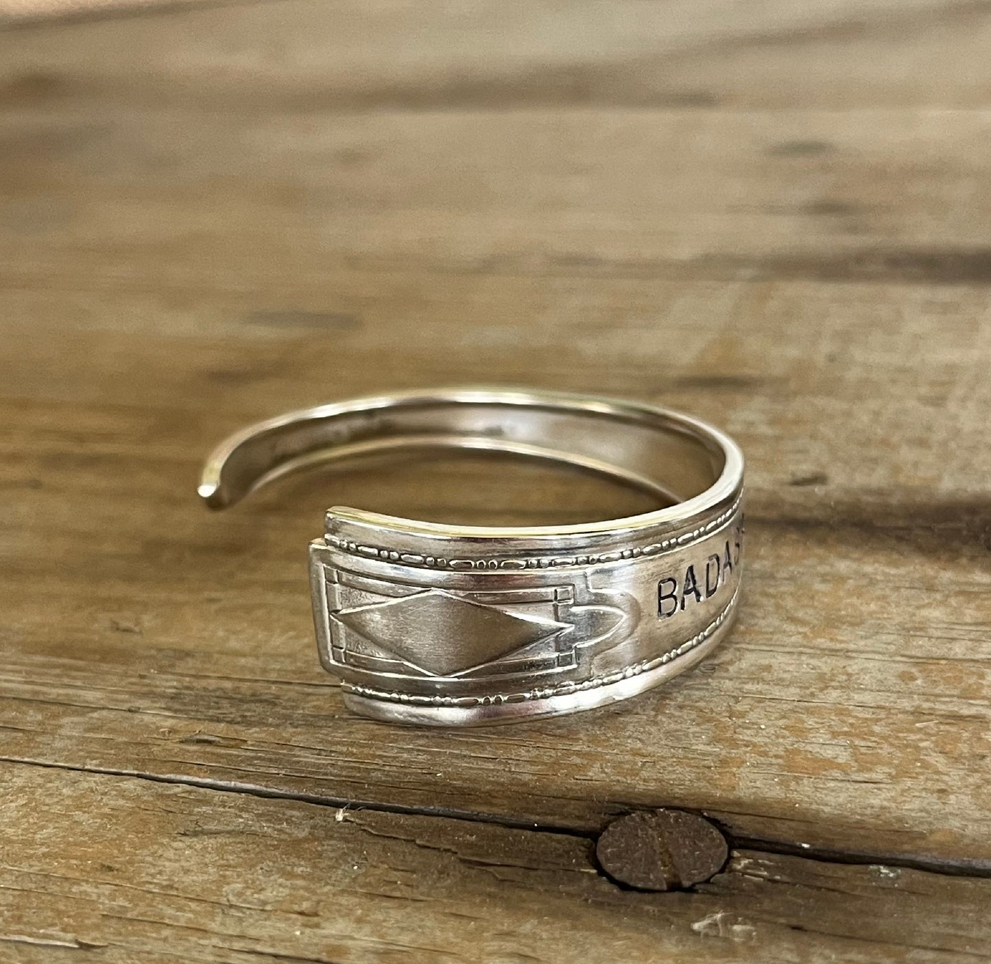 Close-up of BADASS hand-stamped spoon cuff bracelet - Stamped Spoon Bracelet - handcrafted from upcycled vintage silverware - Laughing Frog Studio