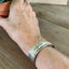 BADASS hand-stamped spoon cuff bracelet shown on model wrist - Stamped Spoon Bracelet - handcrafted from upcycled vintage silverware - Laughing Frog Studio