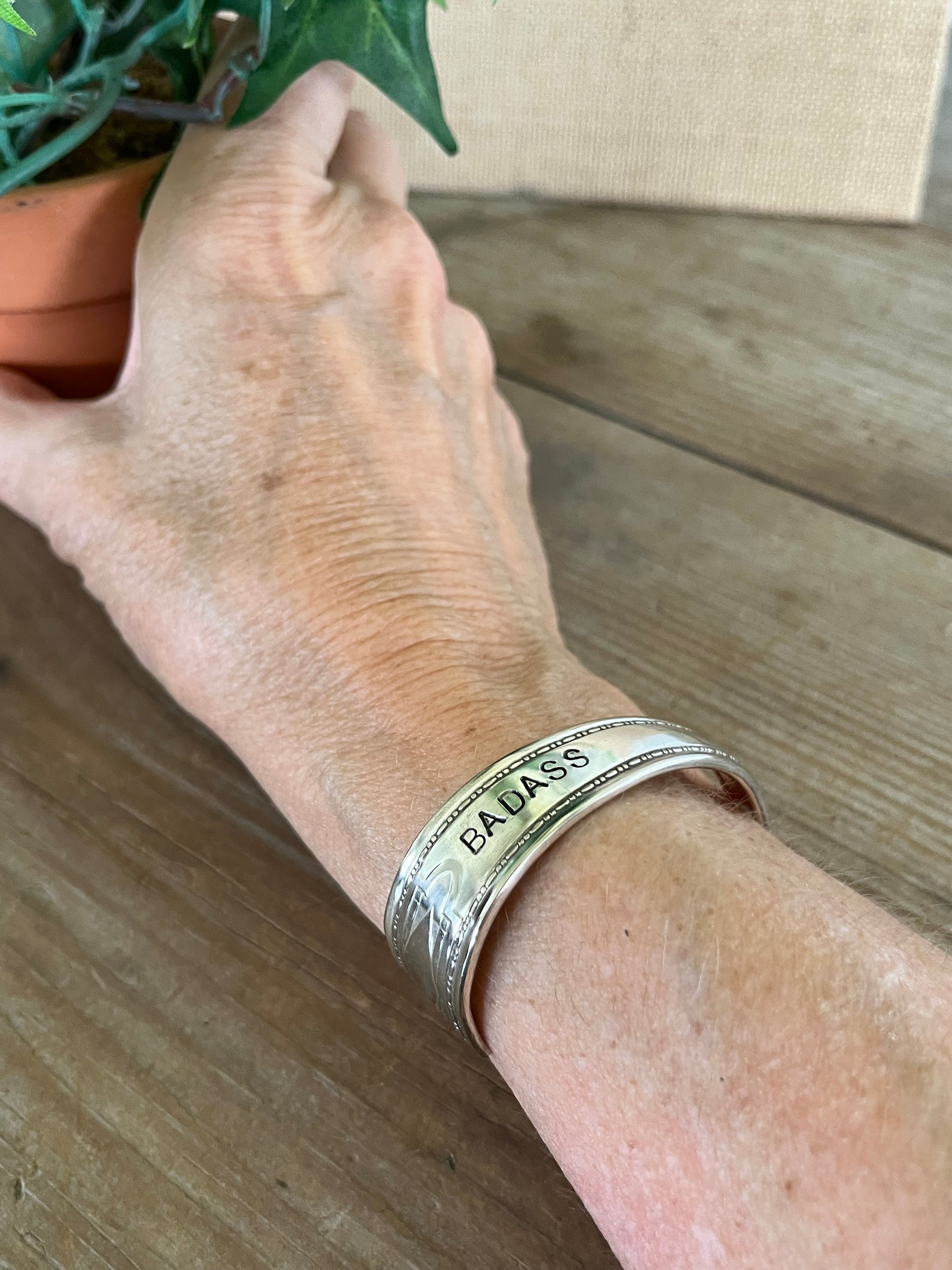 BADASS hand-stamped spoon cuff bracelet shown on model wrist - Stamped Spoon Bracelet - handcrafted from upcycled vintage silverware - Laughing Frog Studio