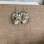 Handcrafted baby spoon bowl earrings with peace bird charms showing unique upcycled silverware design