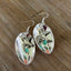 Close-up detail of demitasse spoon bowl earrings with hanging bird charm and faceted dark jadeite bead, 2.375 inches long - Spoon Earrings - handcrafted from upcycled vintage silverware - Laughing Frog Studio