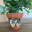 Demitasse spoon earrings with bird of peace charms and jadeite glass beads displayed on flower pot - Spoon Earrings - handcrafted from upcycled vintage silverware - Laughing Frog Studio