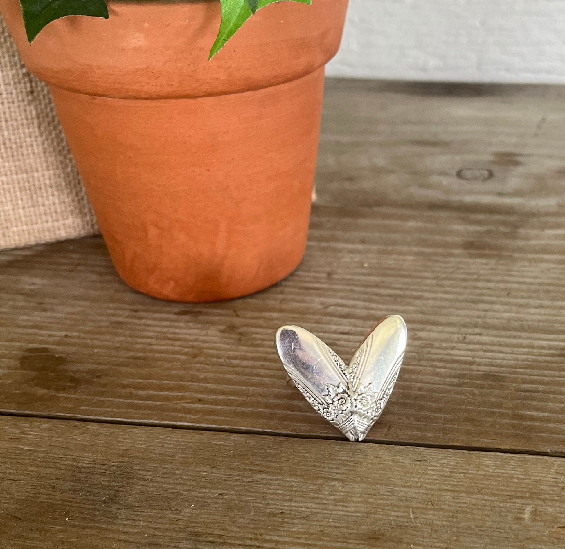 FIRST LOVE pattern sculpted heart statement ring on wood surface - Statement Ring - handcrafted from upcycled vintage silverware - Laughing Frog Studio