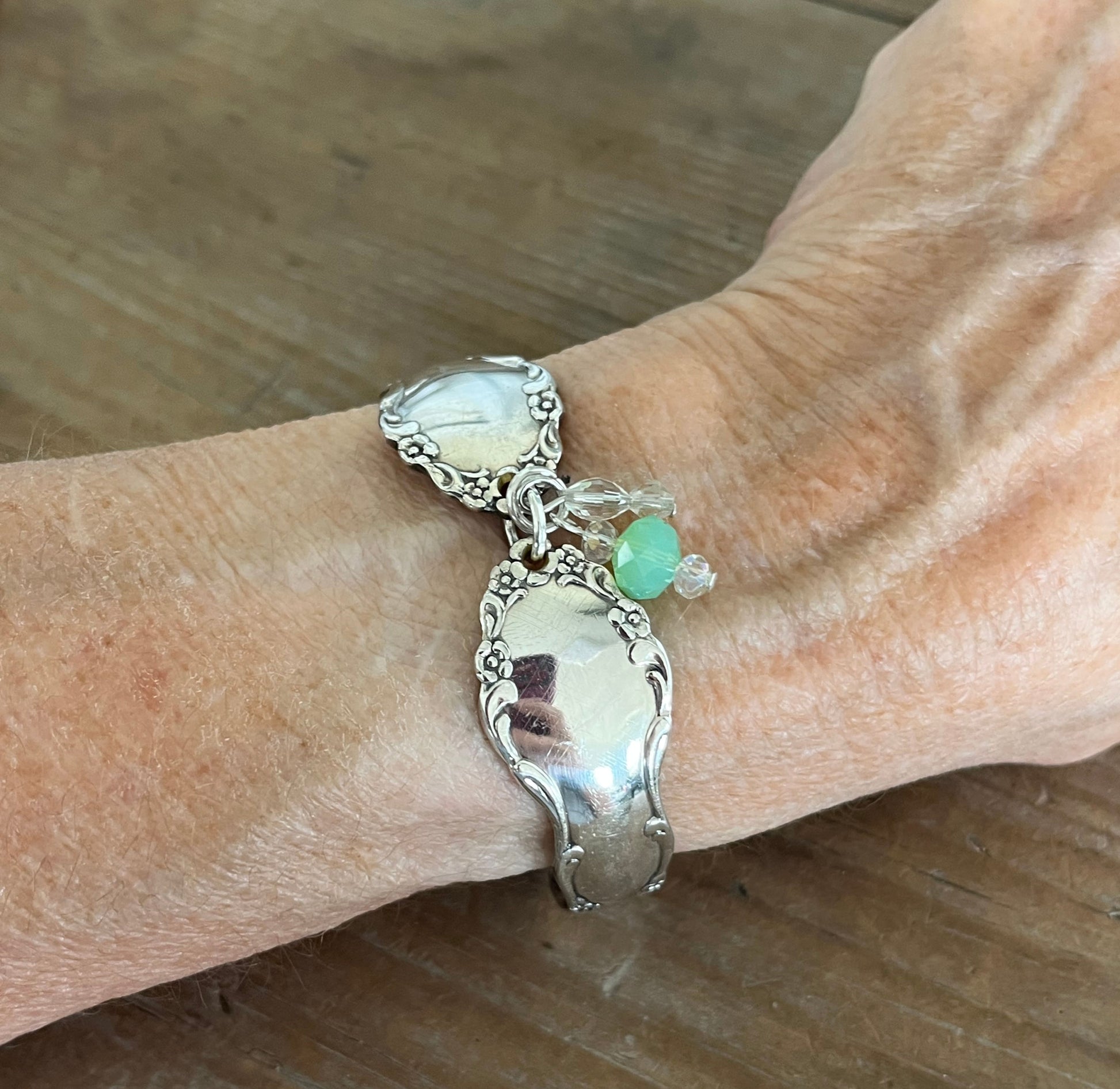 Oneida Dover pattern spoon link bracelet with glass beads modeled on wrist - handcrafted from upcycled vintage silverware - Laughing Frog Studio
