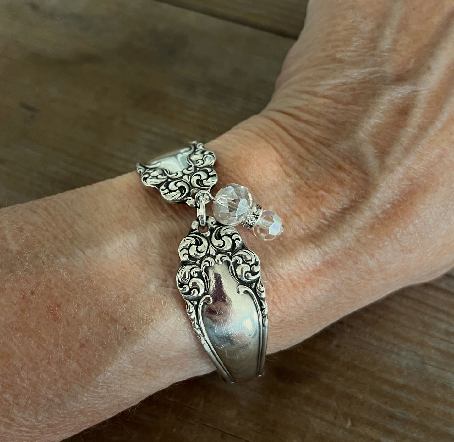 Holmes & Edwards Imperial pattern spoon link bracelet with Czech glass beads shown on a wrist - handcrafted from upcycled vintage silverware - Laughing Frog Studio