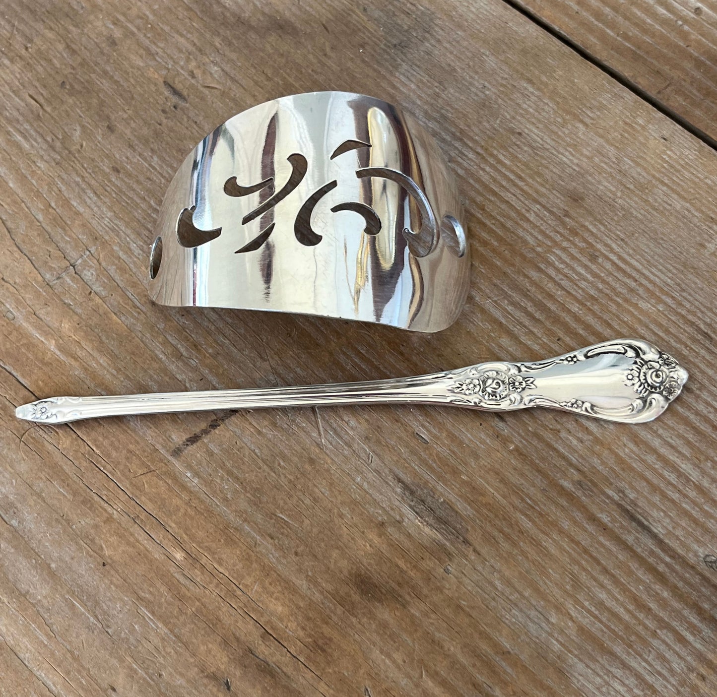 Flat lay of Oneida Vanessa/Francesca cake server hair barrette with stick - handcrafted from upcycled vintage silverware - Laughing Frog Studio