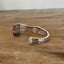 Detailed lfat lay view of Top view of 1949 Old Soutth spoon cuff bracelet with decorative border - upcycled vintage silverware - Laughing Frog Studio