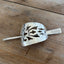 Handcrafted cake server barrette flat lay displaying punched silverware design - upcycled vintage silverware - Laughing Frog Studio