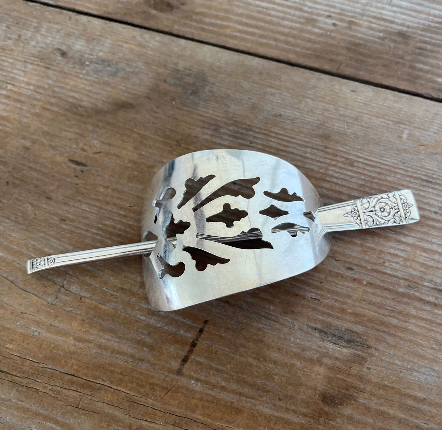 Handcrafted cake server barrette flat lay displaying punched silverware design - upcycled vintage silverware - Laughing Frog Studio