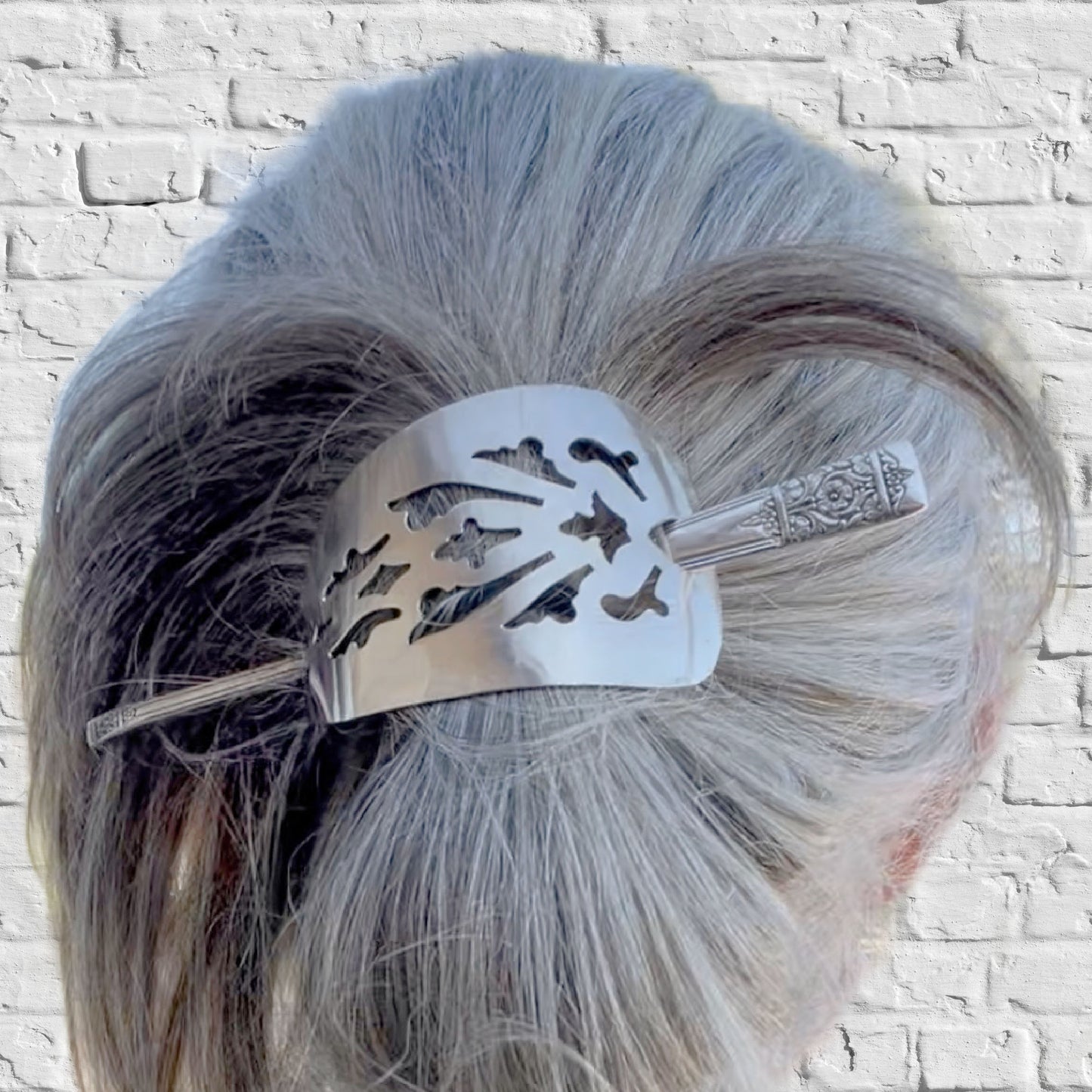 Handcrafted cake server barrette adorning bun hairstyle displaying punched silverware texture in hair upcycled vintage silverware - Laughing Frog Studio