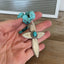 Handcrafted spoon cross pendant on chunky turquoise howlite choker necklace shown in hand for scale - upcycled from vintage Argosy silverware - Laughing Frog Studio