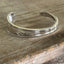 Top view of FUCKITY FUCK FUCK hand-stamped spoon cuff bracelet - Stamped Spoon Bracelet - handcrafted from upcycled vintage silverware - Laughing Frog Studio
