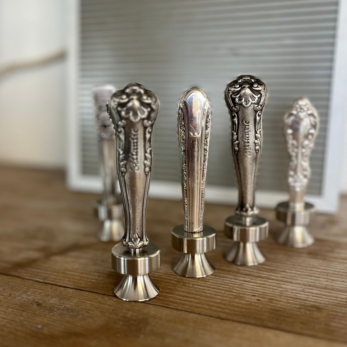 Assorted vintage knife handle bottle openers on wood surface - handcrafted from upcycled vintage silverware - Laughing Frog Studio