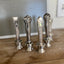 Assorted vintage knife handle bottle openers on wood surface - handcrafted from upcycled vintage silverware - Laughing Frog Studio