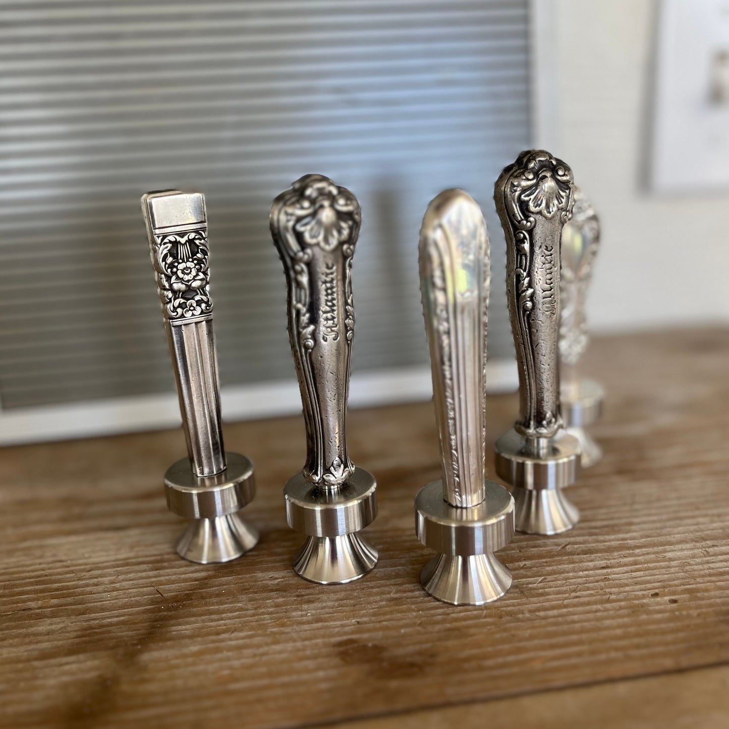 Assorted vintage knife handle bottle openers on wood surface - handcrafted from upcycled vintage silverware - Laughing Frog Studio