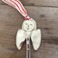 Close up of hand-stamped face of Frances artisan angel ornament with spoon handle body and spoon bowl wings with red striped ribbon hanger - handcrafted upcycled vintage silverware ornament - Laughing Frog Studio
