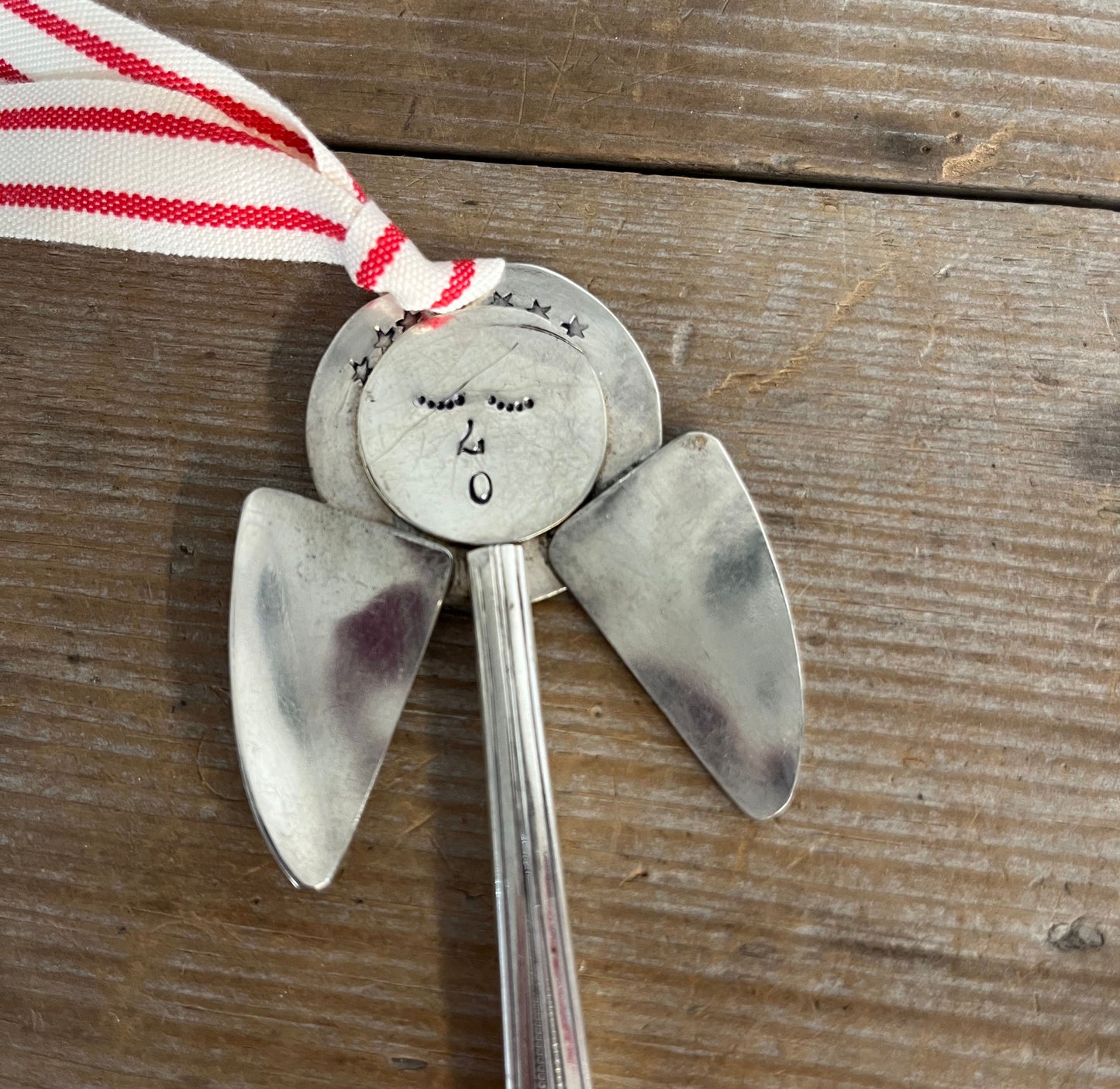 Close-up detail of hand-stamped face of Josephine pattern artisan angel ornament with spoon handle body and spoon bowl wings - handcrafted upcycled vintage silverware ornament - Laughing Frog Studio