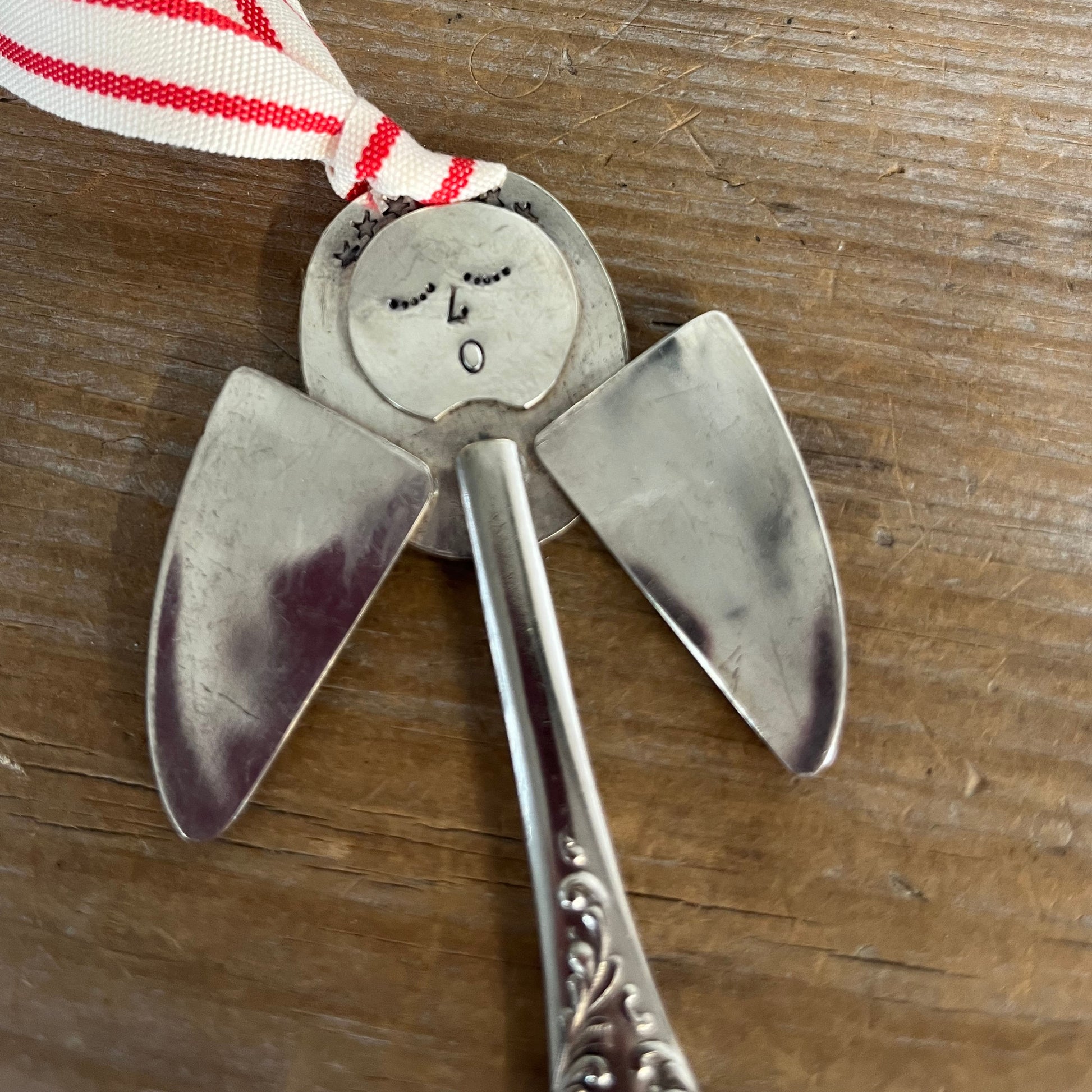 Close-up stamping detail of Pearl artisan angel ornament with spoon handle body and spoon bowl wings with red striped ribbon hanger - handcrafted upcycled vintage silverware ornament - Laughing Frog Studio