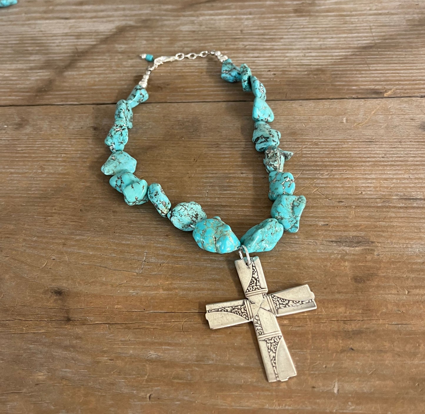 Flat lay display of Nobility Plate Caprice pattern spoon cross pendant on chunky turquoise howlite choker - handcrafted upcycled vintage silverware jewelry - Laughing Frog Studio pattern