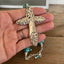 Handmade poon cross pendant on chunky turquoise howlite choker necklace in the Evening Star pattern shown in hand for scale