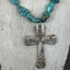 Close-up detail of Fortune pattern spoon cross pendant with turquoise howlite beads - handcrafted upcycled silverware necklace