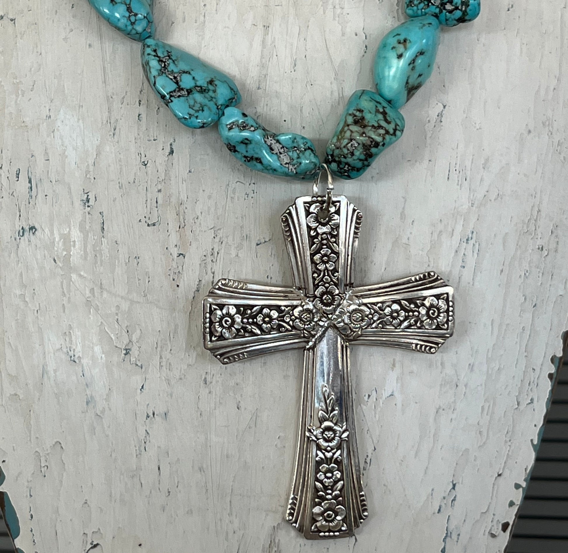 Close-up detail of Fortune pattern spoon cross pendant with turquoise howlite beads - handcrafted upcycled silverware necklace