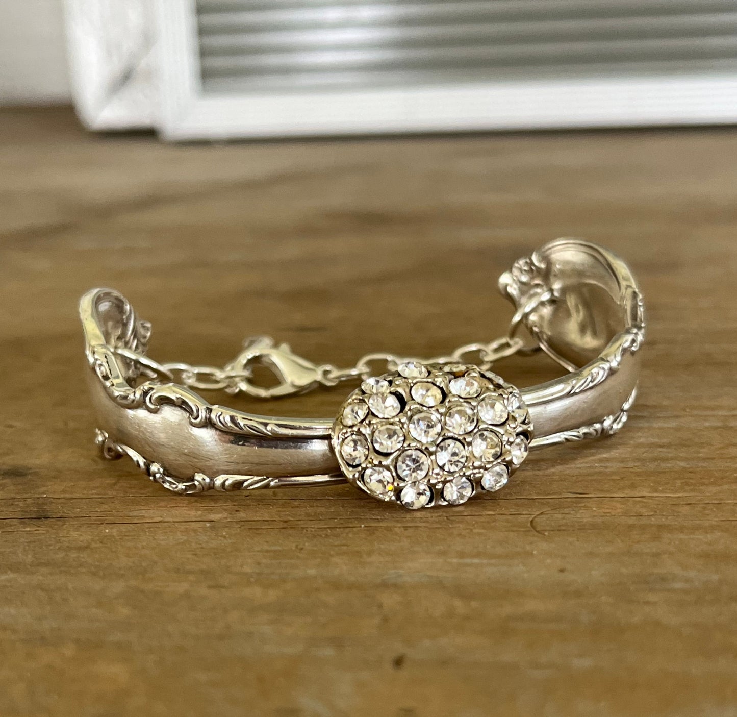 Close up view of vintage rhinestone button centerpiece on Reflection spoon link bracelet - handcrafted from upcycled vintage silverware - Laughing Frog Studio