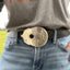 Close-up detail of handmade guitar spoon belt buckle showing hand-stamped scrollwork and drilled sound hole - upcycled vintage silverware - Laughing Frog Studio