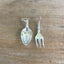 Flat lay of mismatched demitasse spoon and cocktail fork earrings - one-of-a-kind upcycled silverware jewelry - Laughing Frog Studio