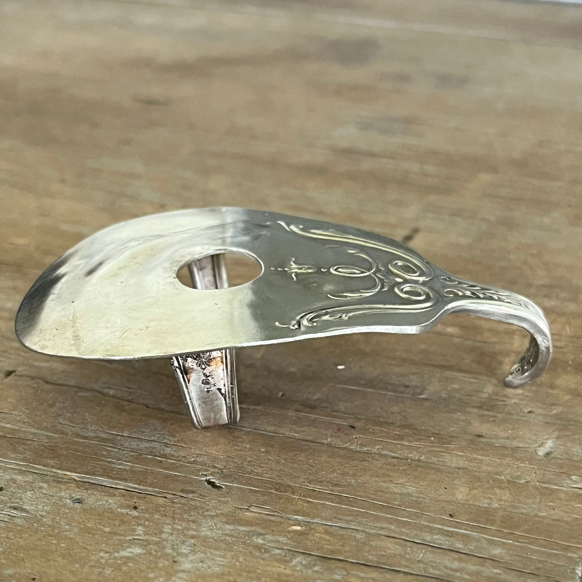 Side view of guitar spoon belt buckle showing depth and guitar body shape - handcrafted from upcycled vintage silverware - Laughing Frog Studio