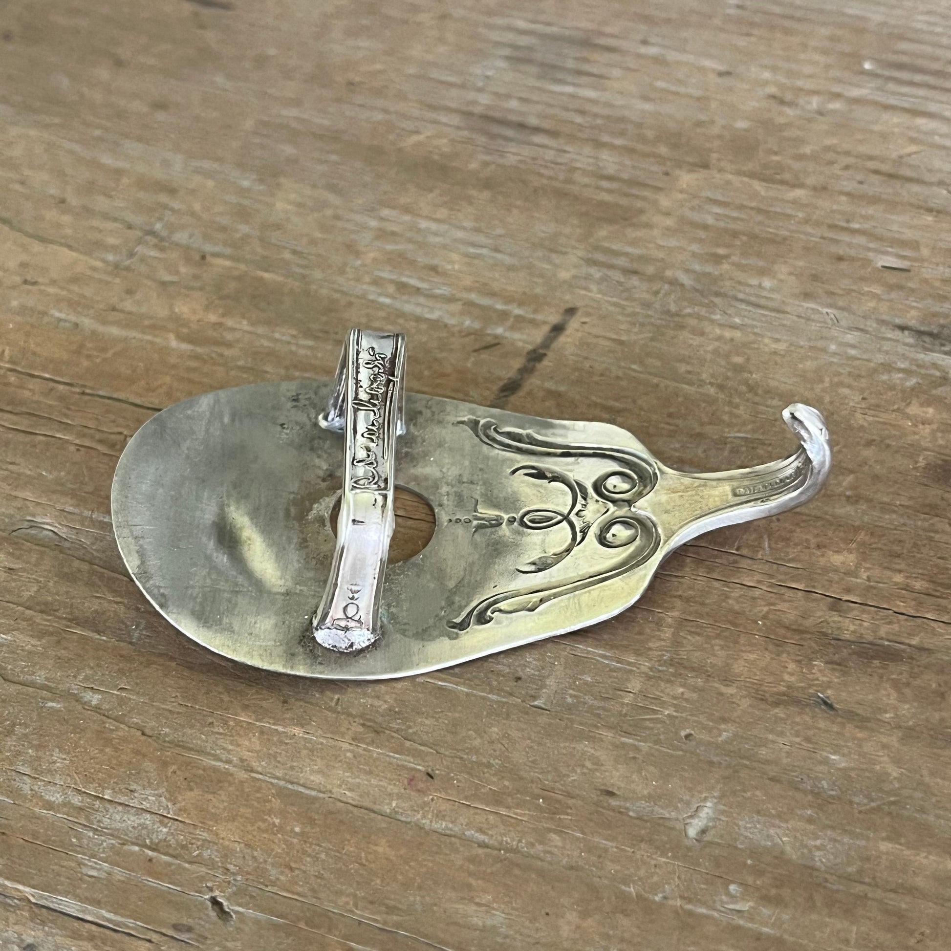 Back view of guitar spoon belt buckle showing upcycled scrap metal catch - handmade one-of-a-kind accessory - Laughing Frog Studio