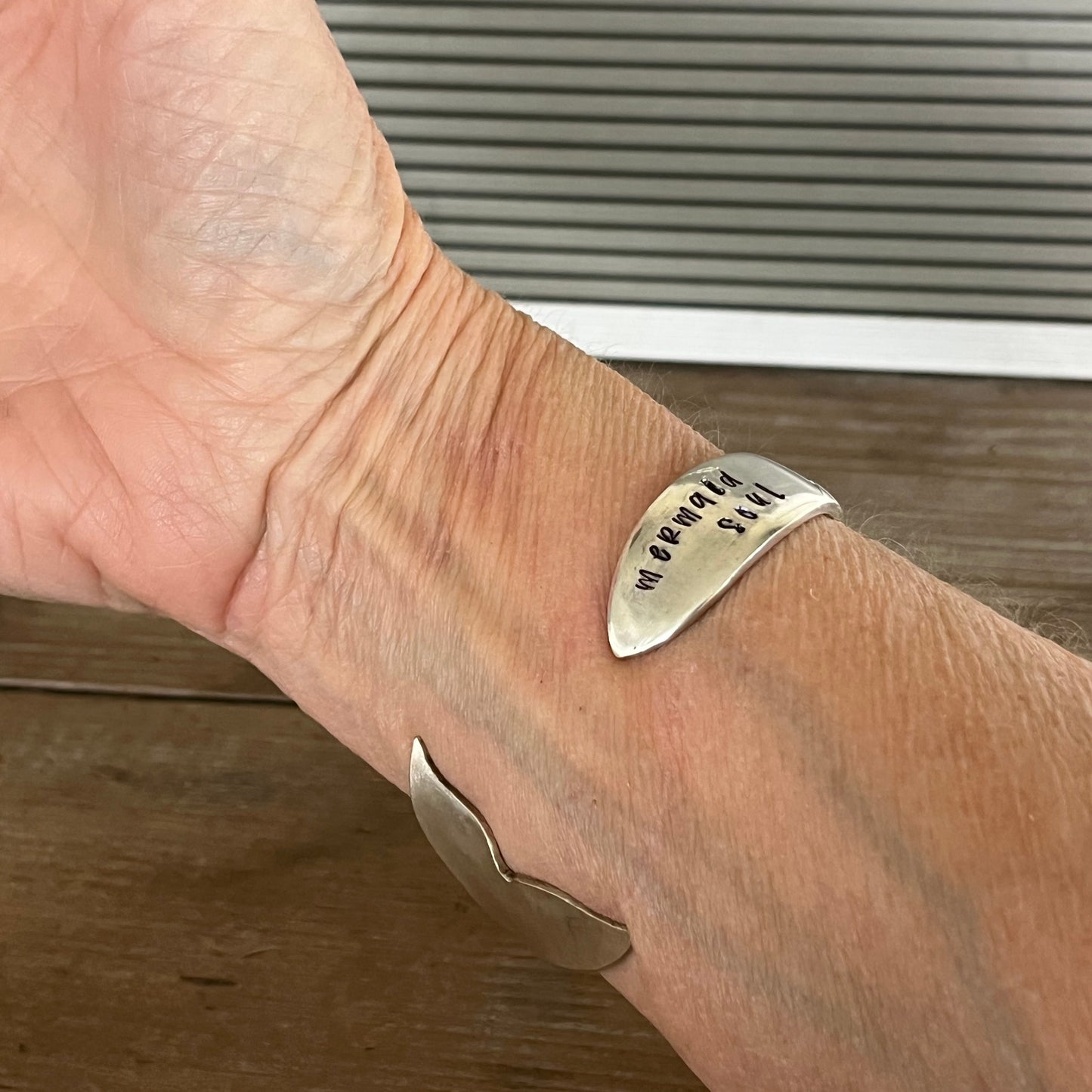 Mermaid Soul spoon cuff bracelet worn on wrist showing stamped spoon bowl and mermaid tail fin - handcrafted from upcycled vintage silverware - Laughing Frog Studio