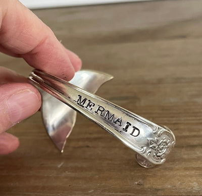 Close-up of hand-stamped "Mermaid" on spoon handle cuff bracelet showing Signature pattern floral engraving - Mermaid Soul Spoon Cuff Bracelet - handcrafted from upcycled vintage silverware - Laughing Frog Studio
