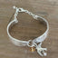 Top view of King Edward spoon link bracelet showing feathery scroll design, silver bird charm, golden crystal bead, and adjustable chain clasp - handcrafted from upcycled vintage silverware - Laughing Frog Studio